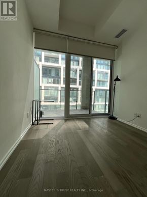Toronto (Mount Pleasant West) condo for rent - A room with wooden flooring and a large window overlooking a cityscape.