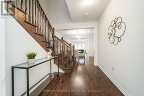 Vaughan (Kleinburg) apartment for rent - A hallway with a wooden staircase and a glass shelf.