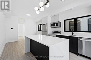 Niagara Falls (Oldfield) condo for rent - A modern kitchen with a white countertop and black appliances.