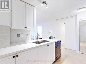 Markham (Unionville) condo for rent - A white kitchen with a sink and cabinets.