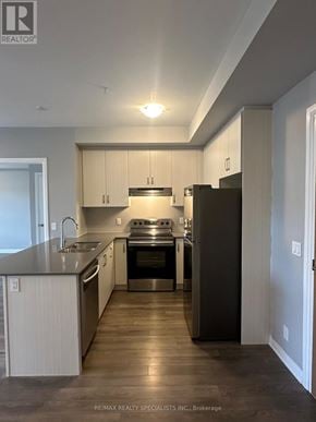 Milton (Fo Ford) condo for rent - A modern kitchen with white cabinets and a dark island.
