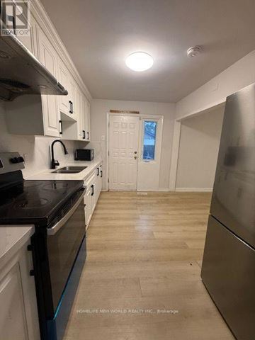 Toronto (Banbury-Don Mills) apartment for rent - A kitchen with white cabinets and a black counter top.