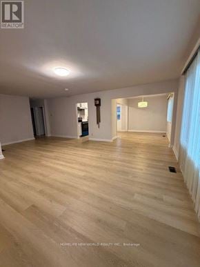 Toronto (Banbury-Don Mills) apartment for rent - A spacious room with wooden flooring and white walls.