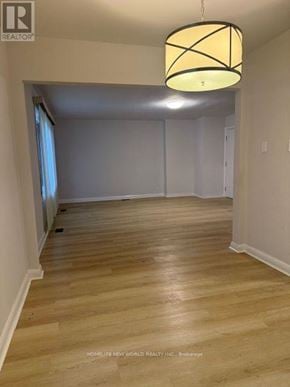 Toronto (Banbury-Don Mills) apartment for rent - A room with wooden flooring and a hanging light fixture.