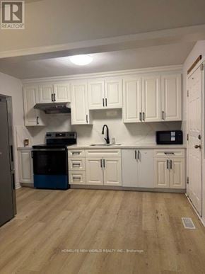 Toronto (Banbury-Don Mills) apartment for rent - A kitchen with white cabinets and a wooden floor.