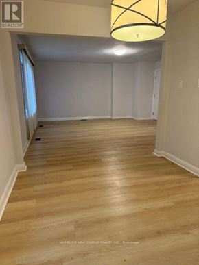 Toronto (Banbury-Don Mills) apartment for rent - A room with wooden flooring and a hanging light fixture.