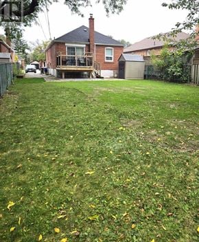 Toronto (Wexford-Maryvale) apartment for rent - A backyard with a lawn and a house in the background.