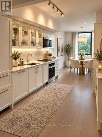 Toronto (Englemount-Lawrence) condo for rent - A well-lit, modern kitchen with white cabinets and a dining area.