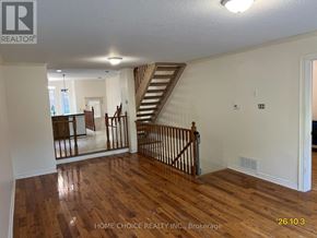 Barrie (Holly) apartment for rent - A spacious room with wooden floors and a staircase.