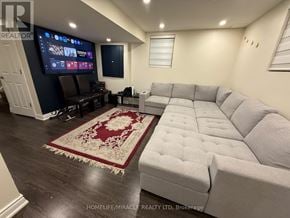 Milton (Ha Harrison) apartment for rent - A living room with a grey couch and a red rug.