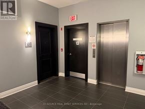 Ottawa condo for rent - A hallway with a door on the left and a fire extinguisher on the right.