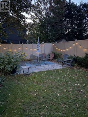 Ottawa condo for rent - A backyard with a fence, chairs, and a table.