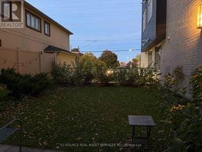 Ottawa condo for rent - A backyard with a bench and a sign that says REALTOR.