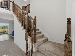 Ottawa apartment for rent - A staircase with a wooden banister and beige carpeted steps.