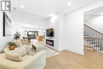 Toronto (High Park-Swansea) apartment for rent - A living room with a couch, a television, and a staircase.