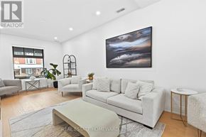Toronto (High Park-Swansea) apartment for rent - A living room with a grey couch, a coffee table, and a painting on the wall.