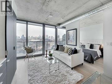 Toronto (Waterfront Communities) condo for rent - A modern living room with a view of the city skyline.