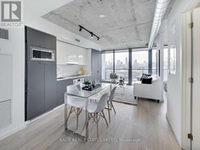 Toronto (Waterfront Communities) condo for rent - A modern kitchen with a dining table and chairs.