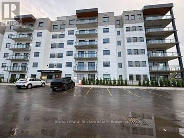 Central Elgin (Port Stanley) multi-family for rent - A white and brown building with a parking lot in front.