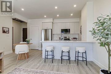 St. Thomas apartment for rent - A well-lit kitchen with white cabinets and a bar area with stools.