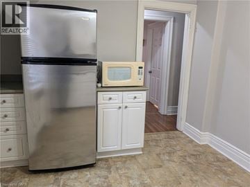 Hamilton apartment for rent - A kitchen with a stainless steel refrigerator and a microwave above a cabinet.
