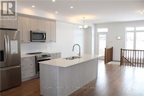 Ottawa townhouse for rent - A modern kitchen with a stainless steel refrigerator, microwave, and oven.