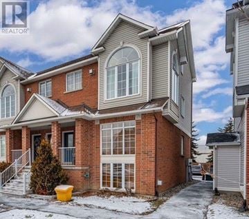 Ottawa condo for rent - A house with a brown brick exterior and a large window on the ground floor.