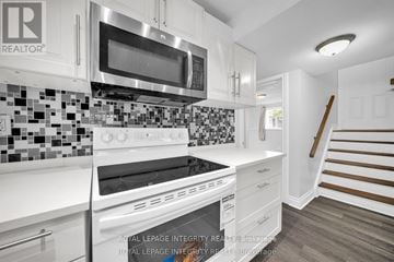 Ottawa apartment for rent - A white kitchen with a stove top oven and microwave.