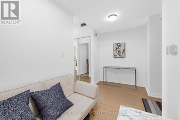Toronto (Waterfront Communities) condo for rent - A living room with a white couch and a painting on the wall.