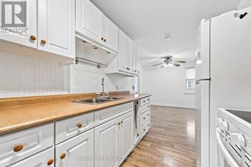 Prince Edward County (Picton Ward) apartment for rent - A kitchen with white cabinets and a wooden countertop.
