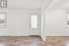 Prince Edward County (Picton Ward) apartment for rent - A room with a white door and a window with a view of a building outside.