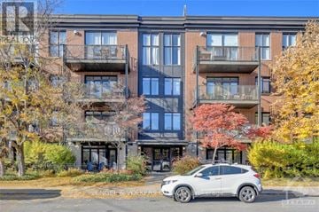 Ottawa condo for rent - A modern apartment building with a car parked in front.