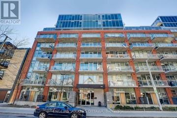 Ottawa condo for rent - A car is parked in front of a building with the sign "Engels & Volkers OTTAWA Brokerage".