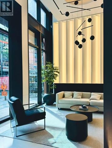 Toronto (Waterfront Communities) condo for rent - A black chair sits in front of a window in a modern living room.