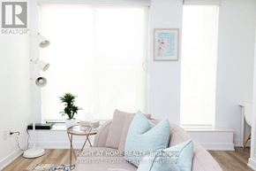 Toronto (Trinity-Bellwoods) condo for rent - A living room with a couch, a table, a lamp, and a plant.