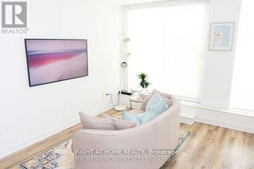 Toronto (Trinity-Bellwoods) condo for rent - A living room with a grey couch and a painting on the wall.