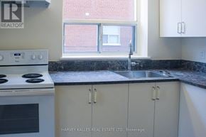 Toronto (Englemount-Lawrence) multi-family for rent - A kitchen with a stove top oven and cabinets.