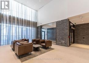 Toronto (Parkwoods-Donalda) condo for rent - A living room with a stone wall and a glass door.
