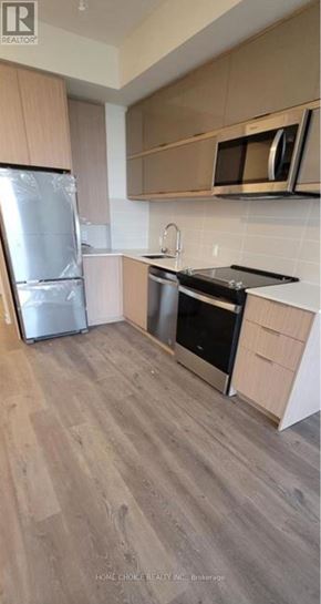 Toronto (Parkwoods-Donalda) condo for rent - A kitchen with a refrigerator, oven, and microwave.