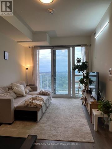 Toronto (Parkwoods-Donalda) condo for rent - A well-lit, spacious bedroom with a large bed and a view of the outdoors through the sliding glass doors.