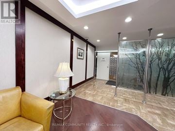 Toronto (Steeles) condo for rent - A living room with a yellow couch and a glass table with a lamp on it.
