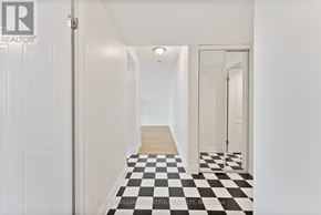 Toronto (Dorset Park) condo for rent - A hallway with a checkered floor leads to a door.