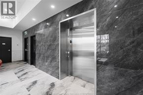 Windsor apartment for rent - A hallway with a marble floor and walls, and a glass elevator.