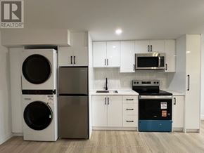 Bradford West Gwillimbury (Bradford) apartment for rent - A white kitchen with a washer and dryer on the left and a dishwasher and oven on the right.