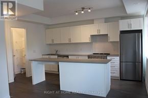 Mississauga (Lakeview) townhouse for rent - A kitchen with white cabinets and a stainless steel refrigerator.