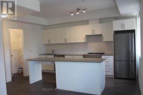 Mississauga (Lakeview) townhouse for rent - A kitchen with white cabinets and a refrigerator.
