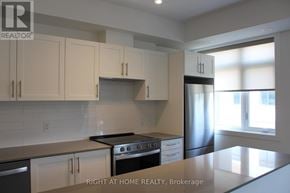 Mississauga (Lakeview) townhouse for rent - A kitchen with white cabinets and a stainless steel refrigerator.