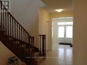 Brampton (Credit Valley) apartment for rent - A hallway with a staircase and a door at the end.