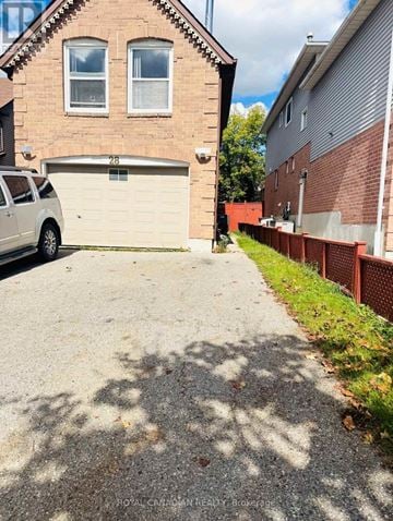 Ajax (Central) apartment for rent - A white car is parked in front of a garage.