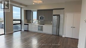 Vaughan (Concord) condo for rent - A modern kitchen with stainless steel appliances and white cabinets.